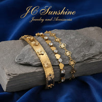 JC Sunshine Jewelry and Accessories gold-plated stainless steel cuff bracelet with flower motifs and cubic zirconia accents.